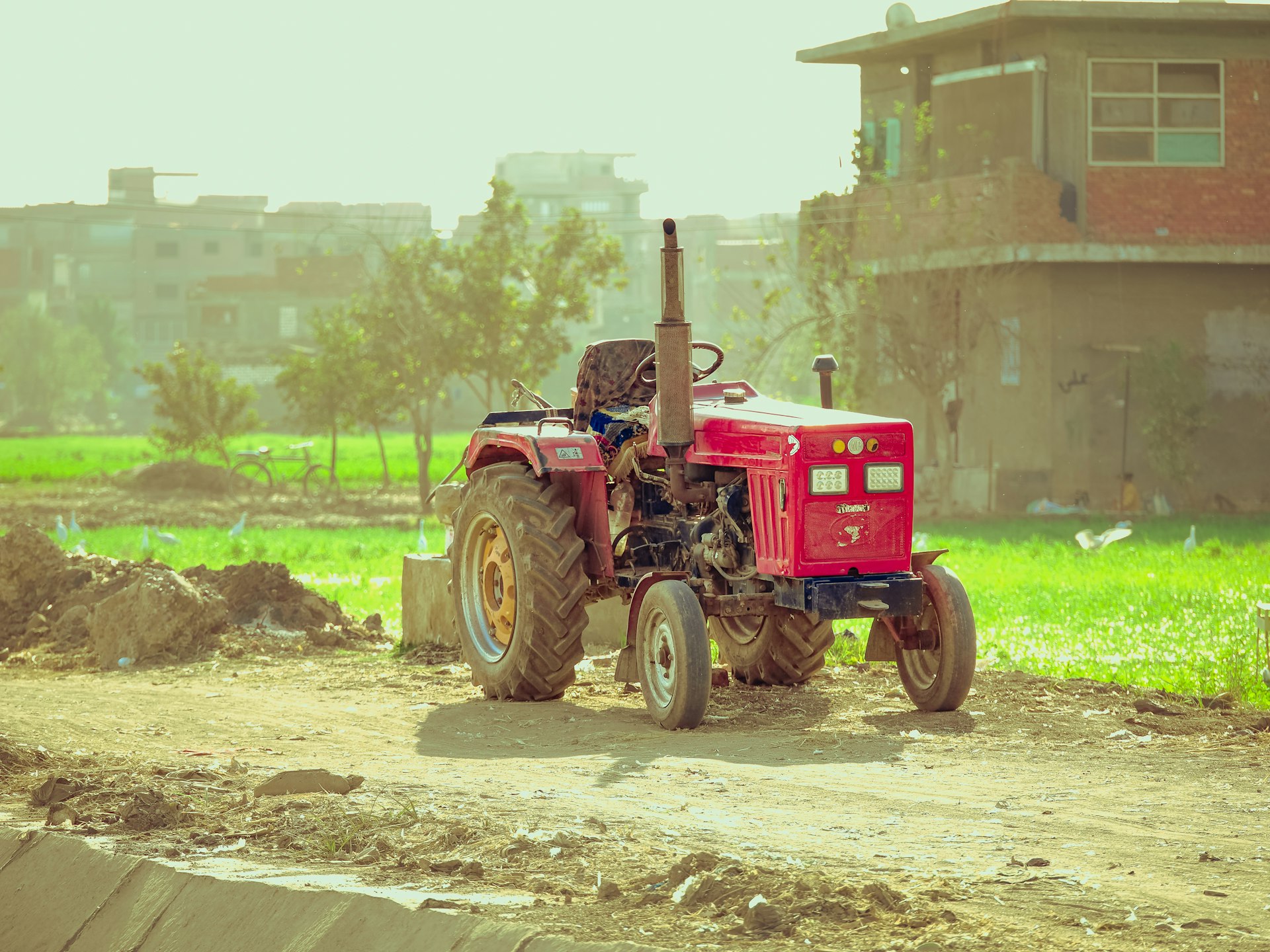A tractor is parked on a dirt road